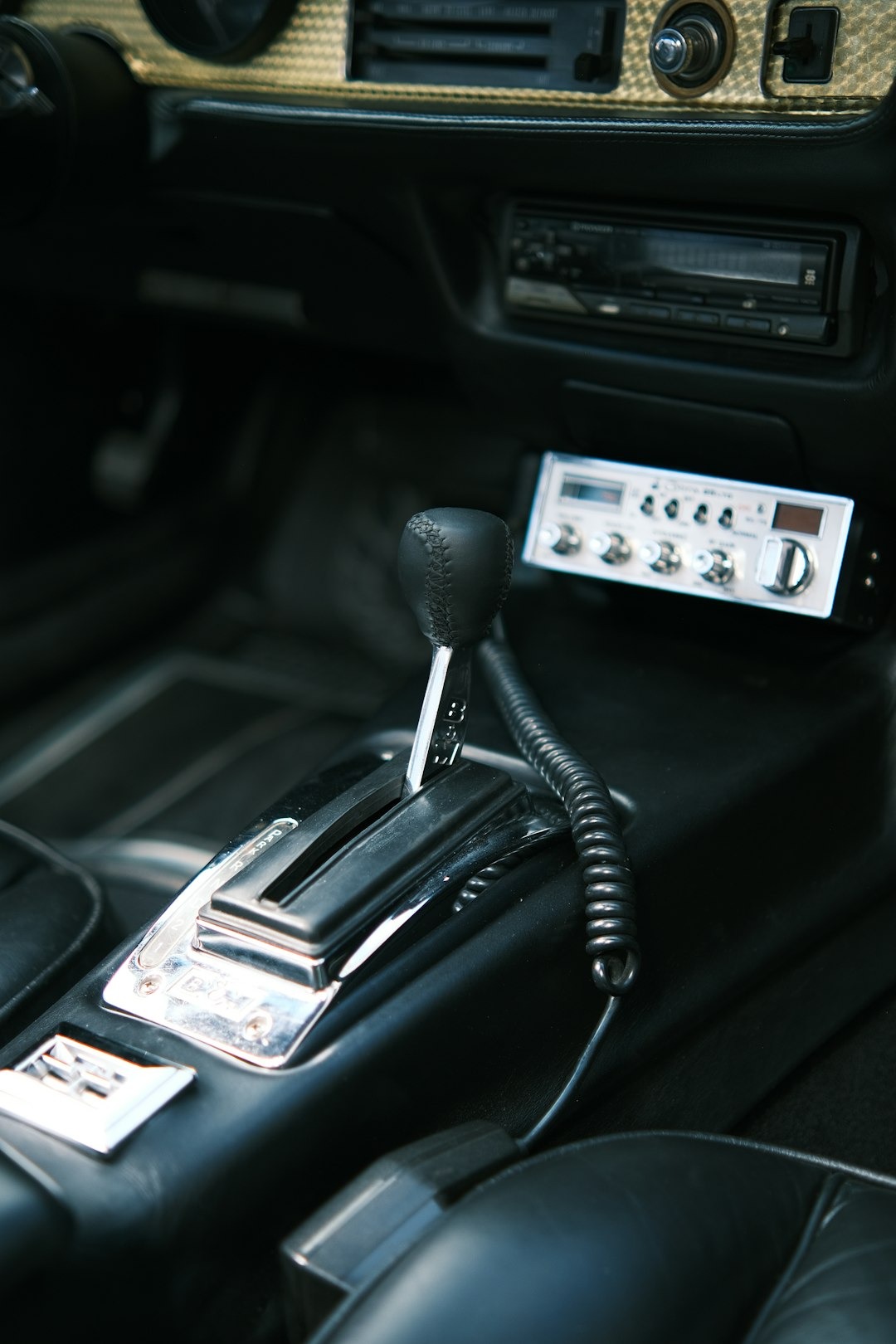 Gear shifter and vintage radio inside a classic car.
