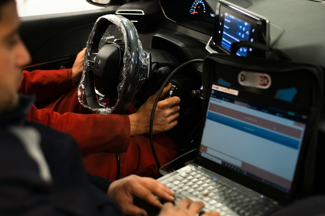 Technicians using diagnostic equipment in a car.